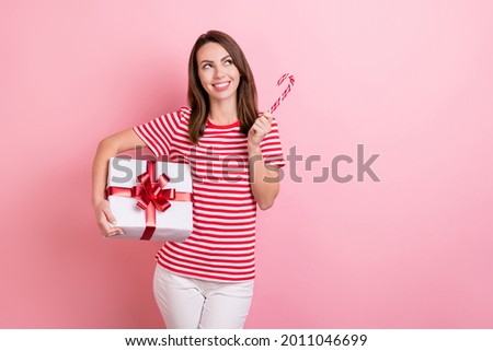 Photo of young girl happy positive smile hold present box sweet candy look empty space isolated over pink color background