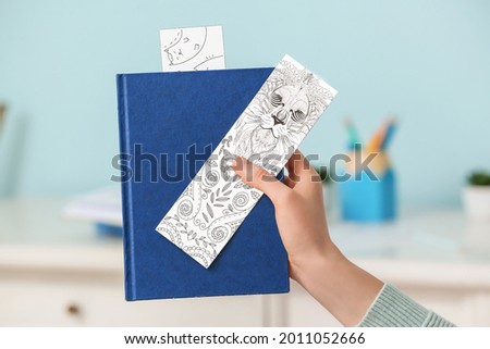 Woman with cute bookmarks and book at home Royalty-Free Stock Photo #2011052666