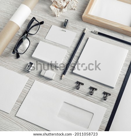 Blank business stationery set on light wood table background.