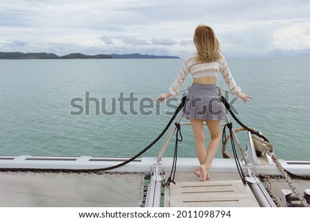 woman standing on yacth out of island