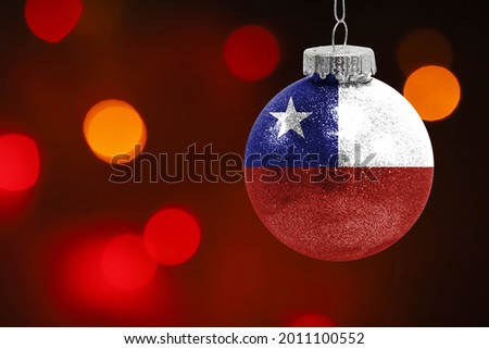 Colorful blurred background and applied the flag of Chile on the New Year's toy. New Year 2022 Celebration