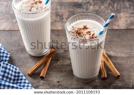 Fresh horchata with cinnamon in glass on rustic wooden table