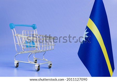 Empty metal shopping basket and Nauru flag on a colored background consumer basket concept