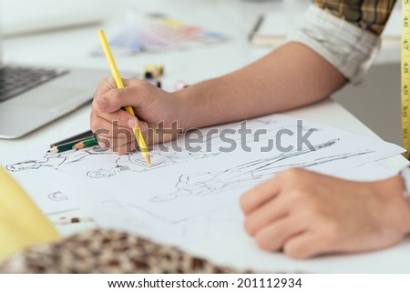 Close-up of designer drawing a fashion sketch