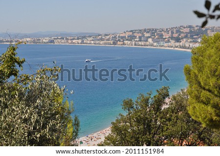 View of the bay of Nice, on the French Riviera, taken from the heights of old Nice - "Vieux-Nice" neighbourhood, on a sunny summer day. The Promenade des Anglais runs along the beach. Royalty-Free Stock Photo #2011151984