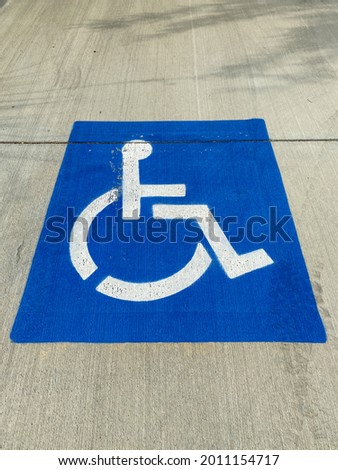 a blue painted disabled parking sign symbol designated car space