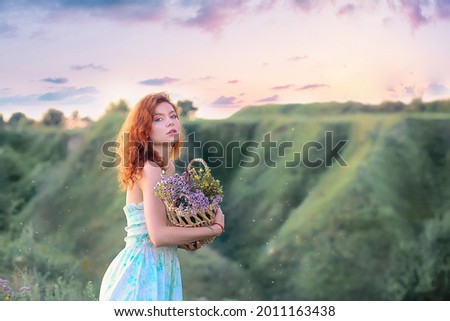 Summer concept. Banner with a  beautiful young girl against the backdrop of a forest landscape and a stunning pink and lilac sunset, in a light summer sundress with a basket. Copy space