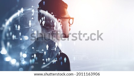 Side view of confident handsome young professional recruiter who is looking for new employees for the international project. Social media people icons and worldwide recruitment process. Royalty-Free Stock Photo #2011163906