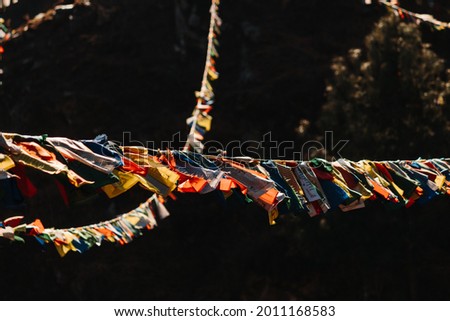 Close-up shot of the Colorful Buddhist Bhutanese Tibetan prayer flag covering the mountains at Pangan Nyingma Monastery in Patlikuhal village near Manali, Himachal Pradesh, India Royalty-Free Stock Photo #2011168583