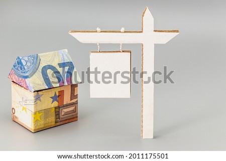 Purchase and sale of housing. Mortgage for the purchase of a house. Rental Property. House folded from euro banknotes with a sign for sale or lease. Origami. Close-up. Copy space
