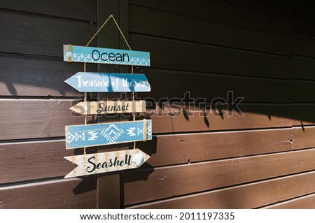Decoration on a garden shed, signpost, direction sign. Paths to the sea and the beach are displayed