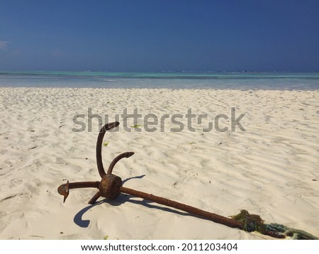 Anchor with rope stuck in the sand during low tide