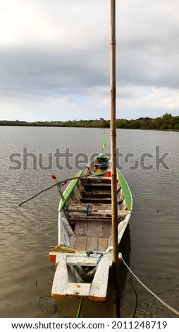 traditional boat made of wood leaning on the shore