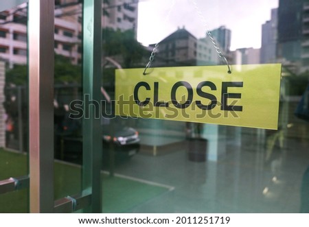  
A sign hanging in front of the glass door of a department store says that the shop is closed for service.                              