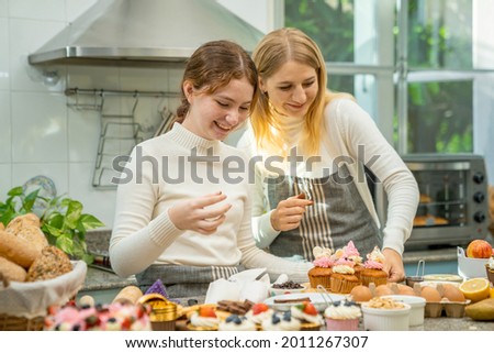 Mother and daughter are happily working together in baking.