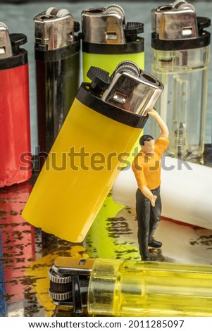 Industry concept with miniature human figures working in gas lighter repair and production