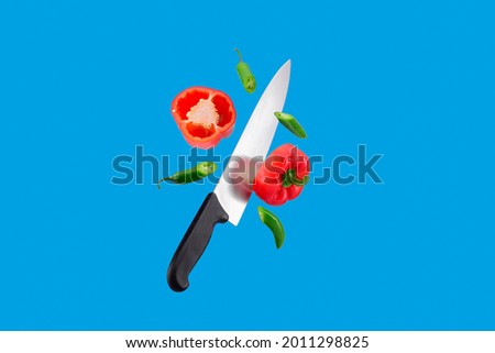 floating knife cuts Mexican chili peppers, red chili and green serrano chili on a blue background minimalism Royalty-Free Stock Photo #2011298825