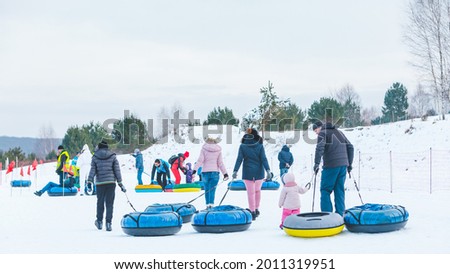 people riding snow tubing at winter park copy space