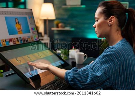 Professional editor doing retouching work on image for design project at office. Graphic artist woman working with touchpad monitor computer and modern digital production equipment