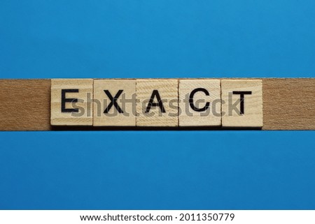 gray word exact in small square wooden letters with black font on a blue background
