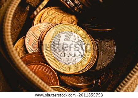 Real - BRL, money from Brazil. Coins inside a coin purse. Photo with view from above and close-up. Emphasis on the 1 real coin. Brazilian finance, spending and economy concept.
