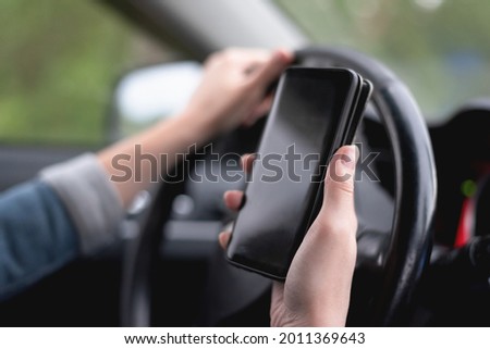 Mobile phone navigation app concept. Mobile phone with blank screen with copy space in the female hands of woman who drives the car.