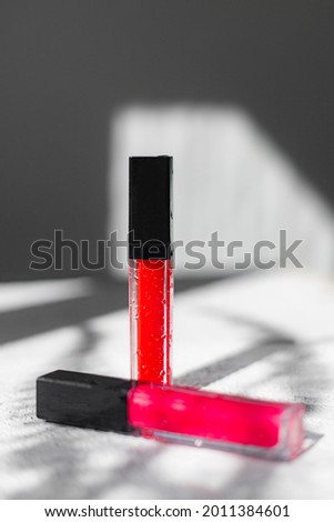 Lip gloss and sun shadow . The concept of lip gloss without labels. Decorative cosmetics. Lip care. Copy space