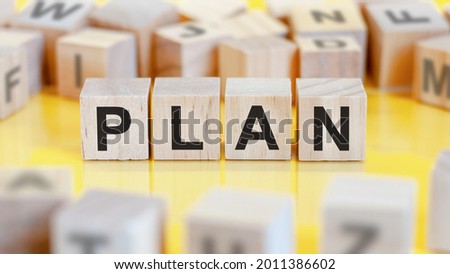 the word plan is written on a wooden cubes structure. blocks on a bright background. financial concept. selective focus.