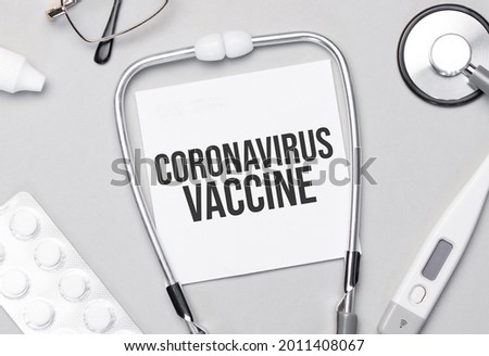 In the notebook is the text Coronavirus Vaccine stethoscope, pills, and glasses.
