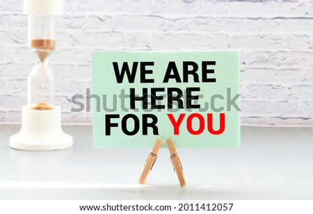 We are here for you handwriting text on paper, on office agenda. Copy space