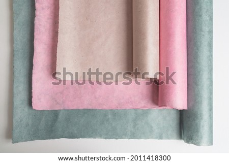 Multicolored soft pastel paper rolls in neutral tones, beige, pink, green. Copy space for text, minimaism concept