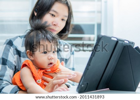Little girl and sister looking cartoon at the tablet, child addicted to cellphone, excessive use of cellphones.