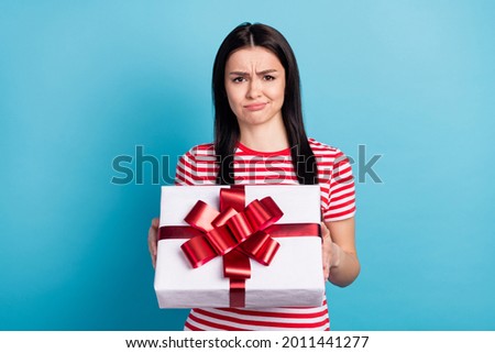 Photo of young girl unhappy sad upset negative dislike surprise present box isolated over blue color background