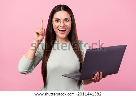 Photo of amazed smart happy mature woman point finger idea hold computer isolated on pink color background