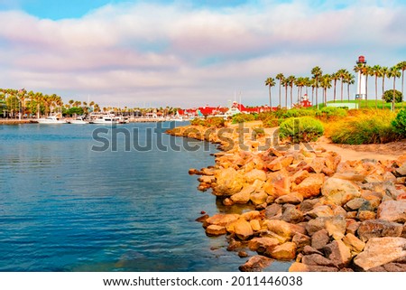 Rainbow Harbor glows in the dusk light with the Pier Point Landing lighthouse standing above it guarding it in Long Beach, California