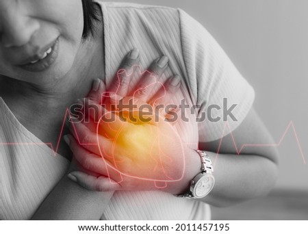 Woman use hand to hole on chest with pain and suffer face from heart disease with heart shape graphic design on top layer. Concept of ST Elevated Myocardial Infarction. Royalty-Free Stock Photo #2011457195