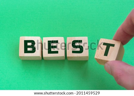 Word best. Wooden small cubes with letters isolated on green background with copy space available. Business Concept image.