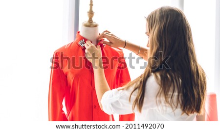 Portrait of young beautiful pretty woman fashion designer stylish working with mannequins standing and colorful fabrics at fashion studio