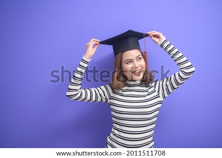 A portrait of young woman graduated over blue background 