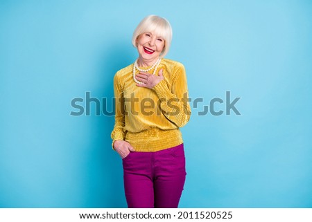 Photo of cheerful short hairdo aged lady wear blouse pants isolated on blue color background