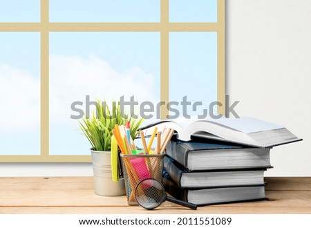 Desk with book and stationery with a window glass background. Back to School concept