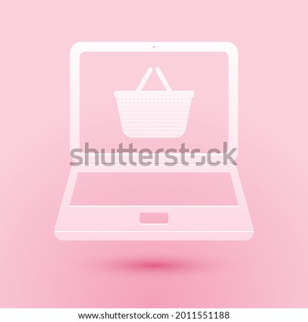 Paper cut Mobile phone and shopping basket icon isolated on pink background. Online buying symbol. Supermarket basket symbol. Paper art style..