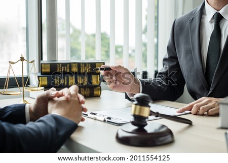 Male lawyers or a judge counseling clients about judicial justice and prosecution with scales, judges gavel, legal documents legal services concept.