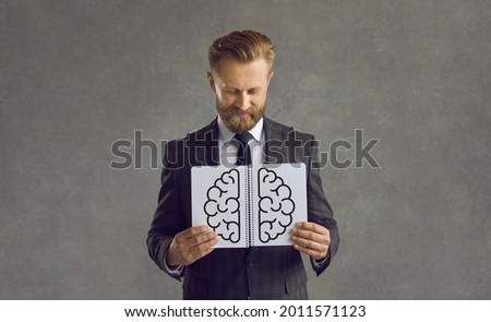 Happy successful smart creative business man, corporate worker, entrepreneur, human resources staff hiring manager with picture of brain in open notebook. Professional development, headhunting concept