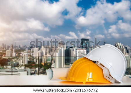 Construction house and building. Repair work. Drawings for building and helmet on white table.