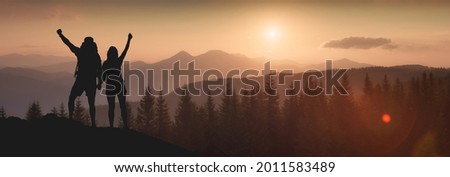 Young happy couple hikers enjoy the sunset in carpathian mountains. Wild nature of Ukraine.