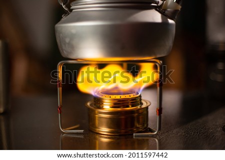 Boiling kettle on alcohol stove . Image contain Noise and Grain,Soft focus image due to lowlight and High ISO shot. selective focus 