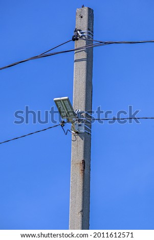Street lighting lamp on a concrete pole of a power line
