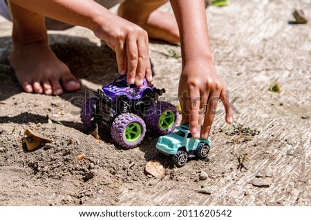 Little child's hand playing with toy car.