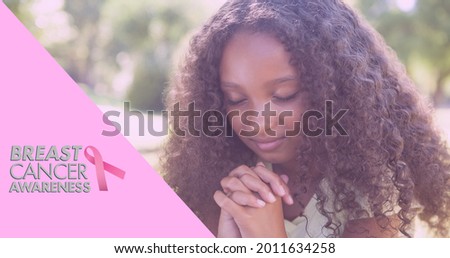 Composition of pink ribbon logo and breast cancer text, with praying schoolgirl. breast cancer positive awareness campaign concept digitally generated image.